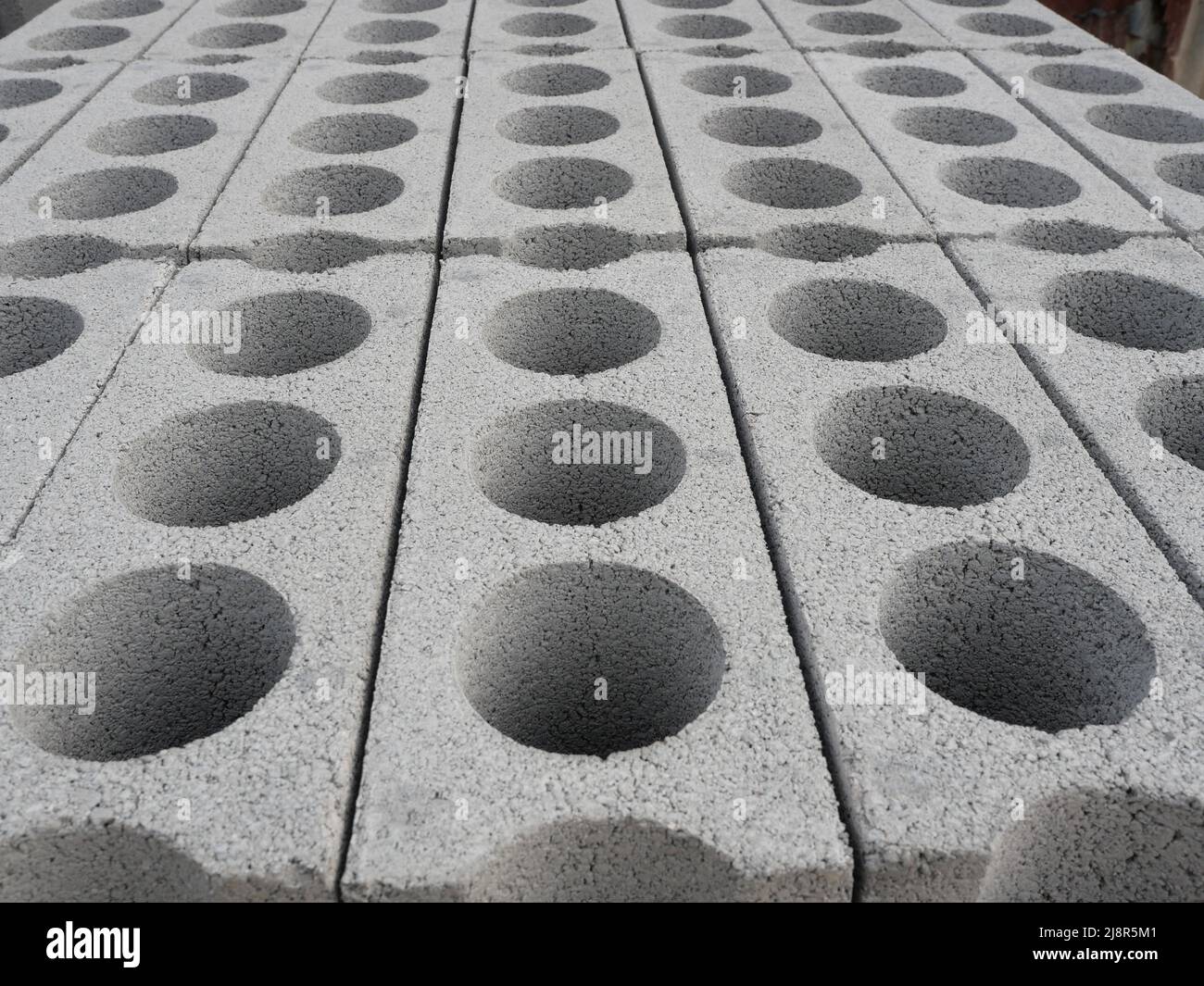 Trou circulaire sur brique blanche, texture rugueuse et poreuse des matériaux de construction gris, Groupe de blocs de cinder isométriques Banque D'Images