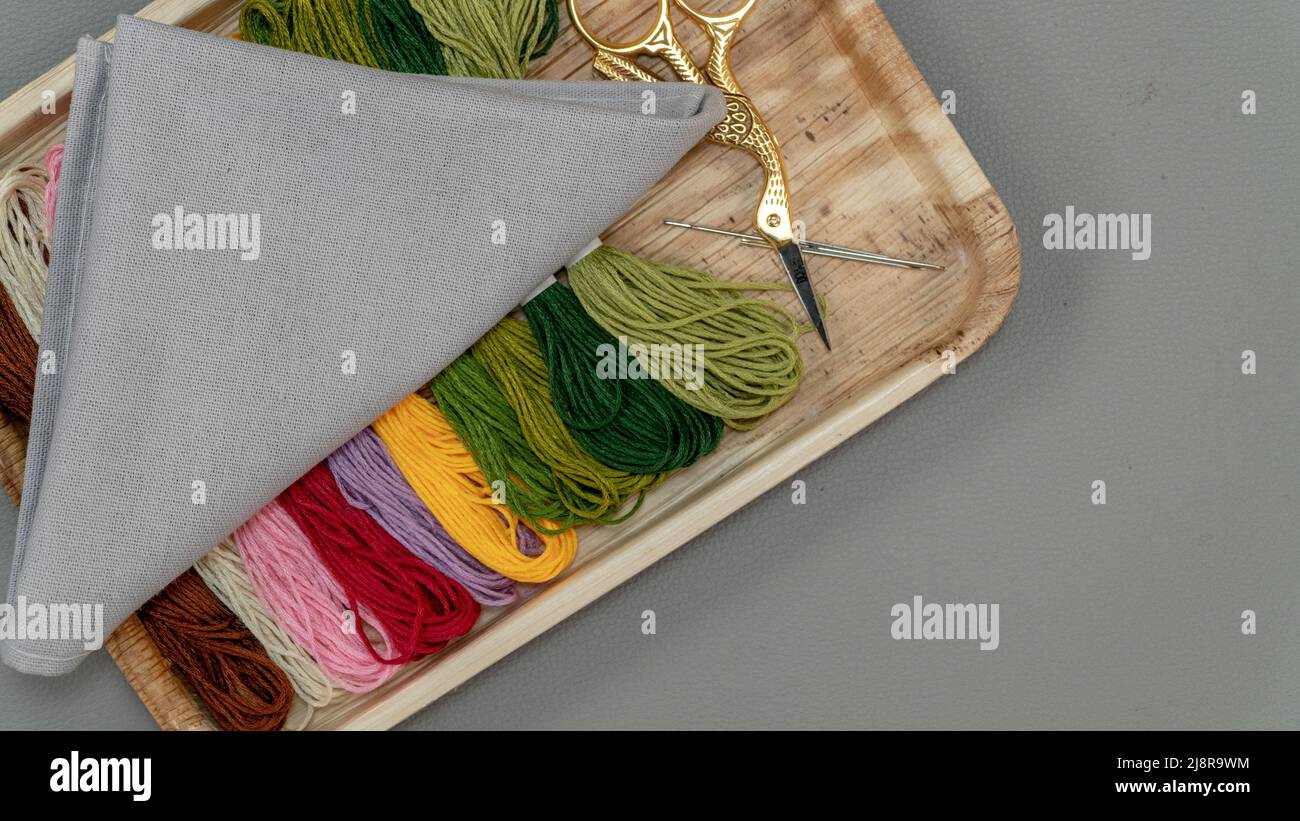 Préparations pour la broderie avec fil de soie gris et multicolore, toutes pour la couture croisée (Cross-Stitch). Banque D'Images