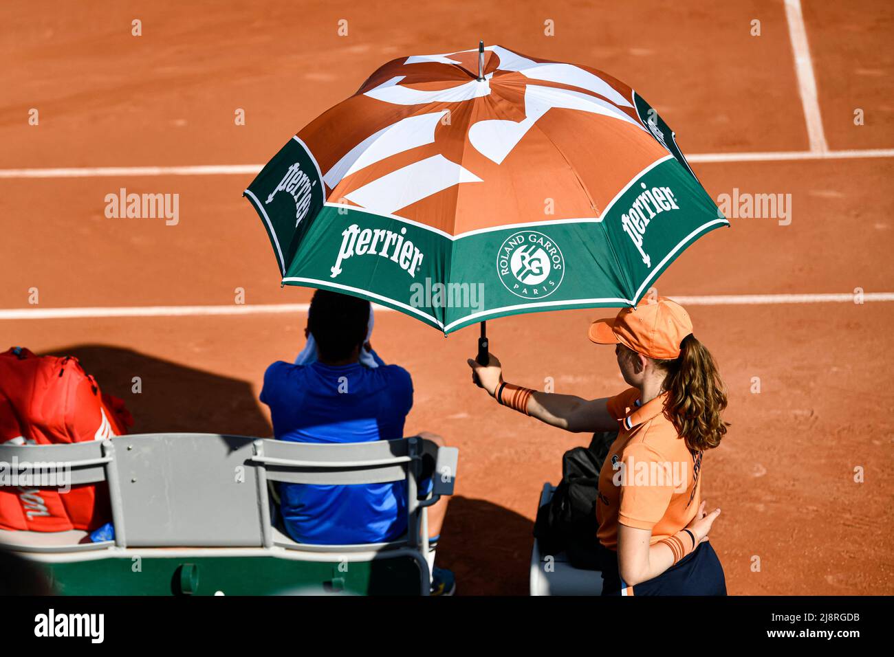 L'illustration montre le parapluie ou le parasol tenu par un gamin  au-dessus d'un joueur en raison de la chaleur pendant l'Open de France ( Roland-Garros) 2022, Grand Chelem tournoi de tennis le 17