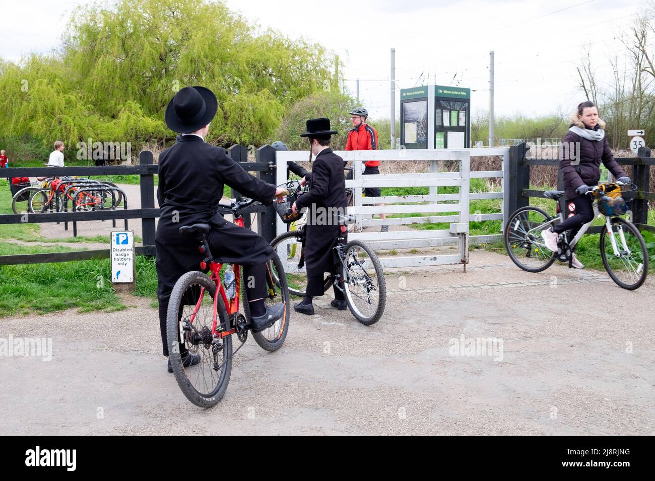 Des garçons juifs orthodoxes en vélo sur une piste cyclable traversant la porte de la réserve naturelle Walthamstow Wetlands à Londres, Angleterre KATHY DEWITT Banque D'Images