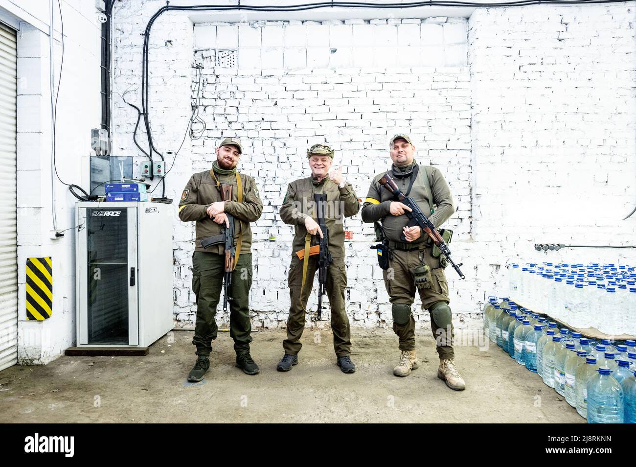 Trois membres de la Force de défense territoriale du quartier de Kotsiubynske vus avec leurs fusils à Kiev. Banque D'Images