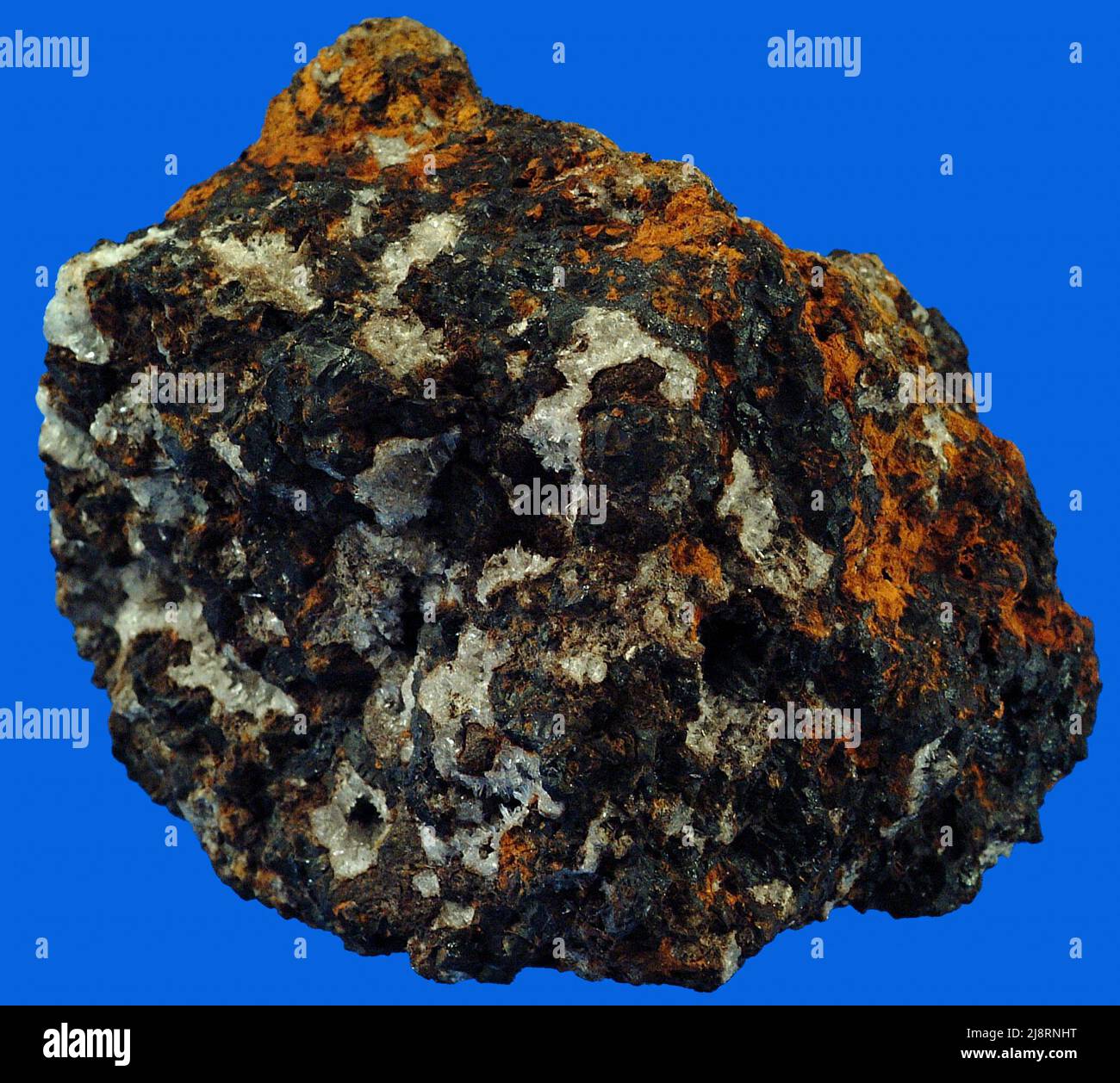 Franklinite, calcite et hémimorphe. L'hémimorphe était à l'origine appelée calamine, mais ce nom avait été utilisé pour un autre minéral et l'hémimorphe a été proposé et est maintenant en utilisation à grande échelle. Il est dans cet échantillon avec la franklinite et la calcite. L'hémimorphe et la franklinite sont toutes deux des minerais de zinc. Banque D'Images