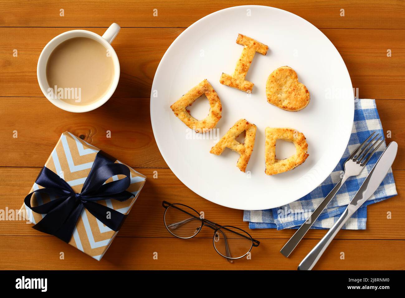 Brunch du jour des pères avec pâtisserie maison J'aime papa, boîte cadeau, tasse de café, couverts sur table en bois. Banque D'Images