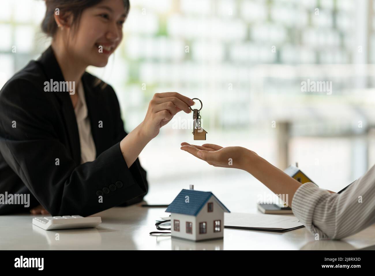 agent immobilier tenant la clé de maison à son client après signature de contrat dans le bureau, concept de l'immobilier, déménagement de maison ou location de propriété Banque D'Images