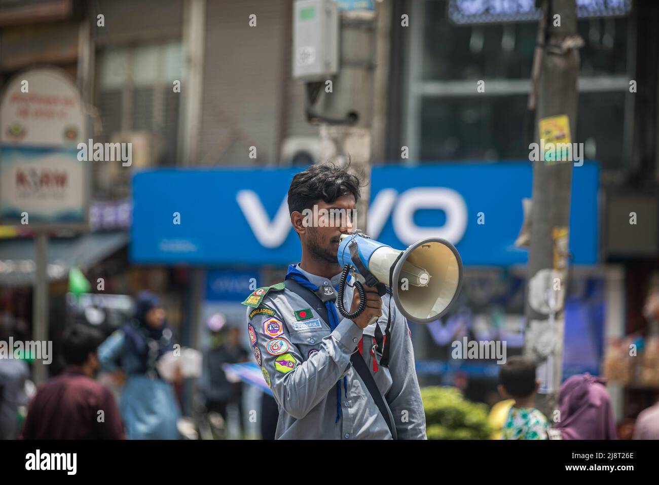 Un membre de Rover Scout scanne des slogans de sensibilisation à travers un mégaphone dans la rue pendant la campagne No Horn à Dhaka. La pollution sonore est devenue un problème important au Bangladesh. Le ministère de l'Environnement, sous la direction du ministère de l'Environnement, des forêts et des changements climatiques, a organisé une campagne « No Horn » et un tribunal mobile le 17th mai pour réduire la pollution sonore. La campagne se déroulera de 11 h à 4 h dans les intersections Gulshan-1. Cette campagne & Mobile court est destinée à développer la conscience des conducteurs et des propriétaires de véhicules. Pour qu'ils puissent réaliser les démerses de la pollution sonore et de contrôle t Banque D'Images