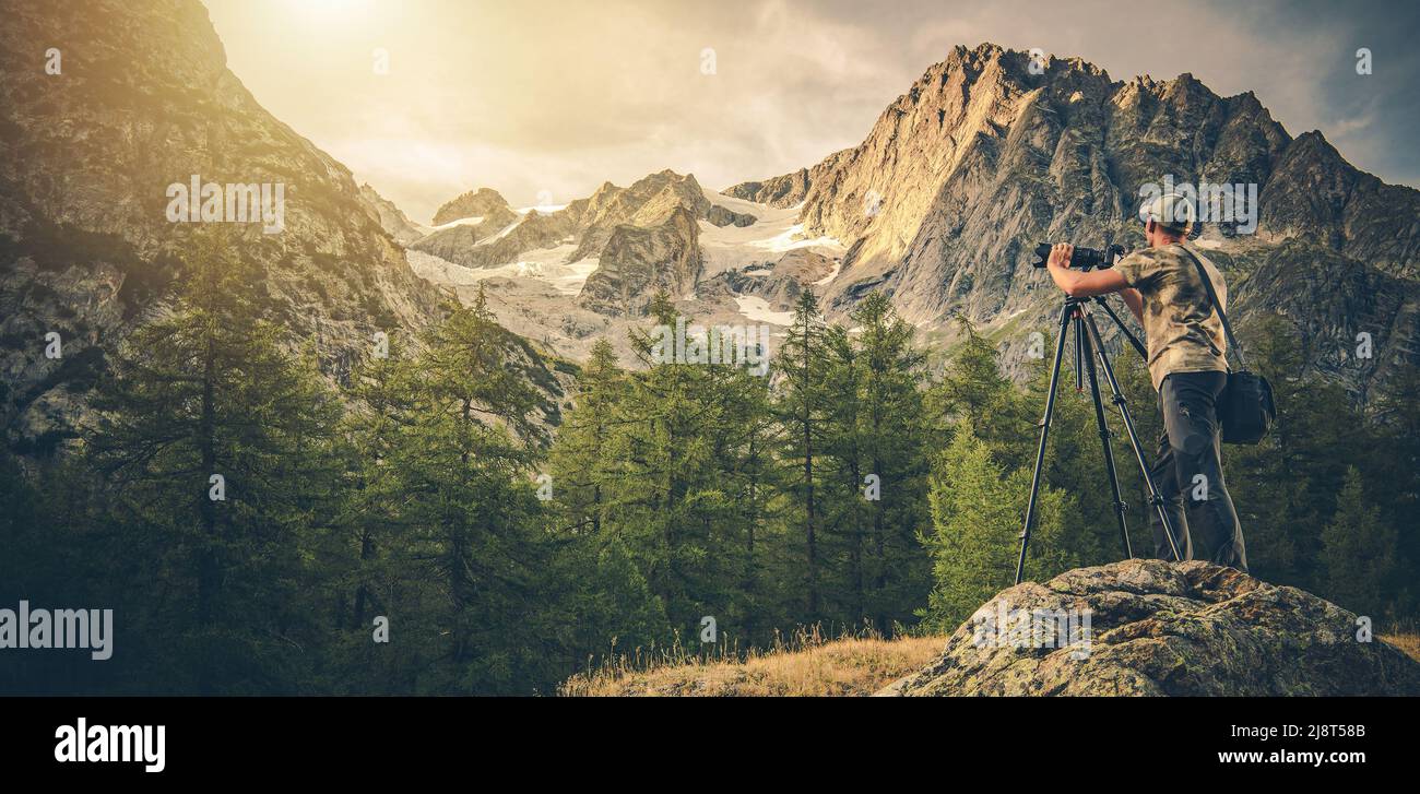 Photo panoramique de l'amateur de photographie caucasienne dans son 40s prendre des photos de paysage à l'aide d'un appareil photo numérique avec trépied. Paysage alpin pittoresque. Banque D'Images