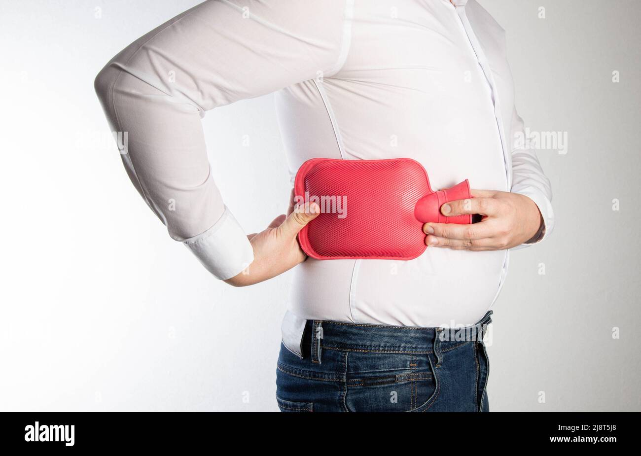Un homme tient un bloc chauffant rouge avec de l'eau près du côté de son dos. Le concept de traitement des entorses, de l'hypothermie des muscles et des ligaments. Thermot Banque D'Images
