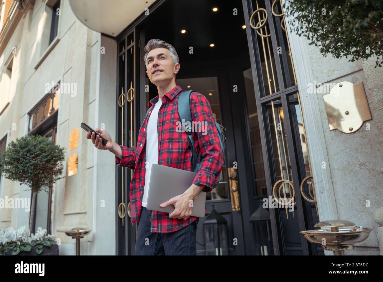 Homme avec un ordinateur portable et un smartphone regardant de côté Banque D'Images