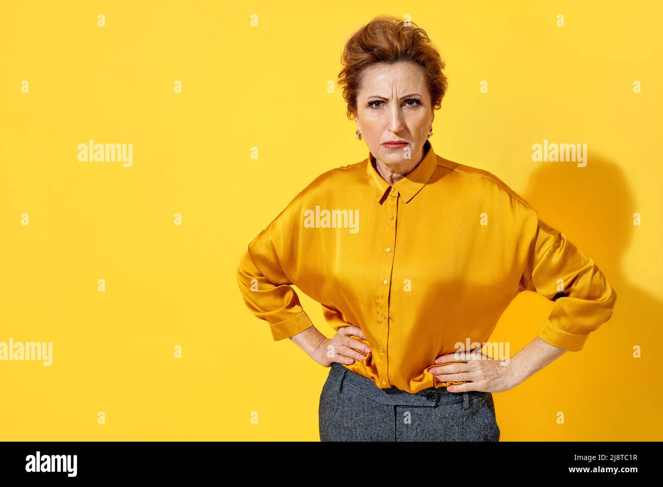 Femme en colère en chemise jaune sur fond jaune Banque D'Images