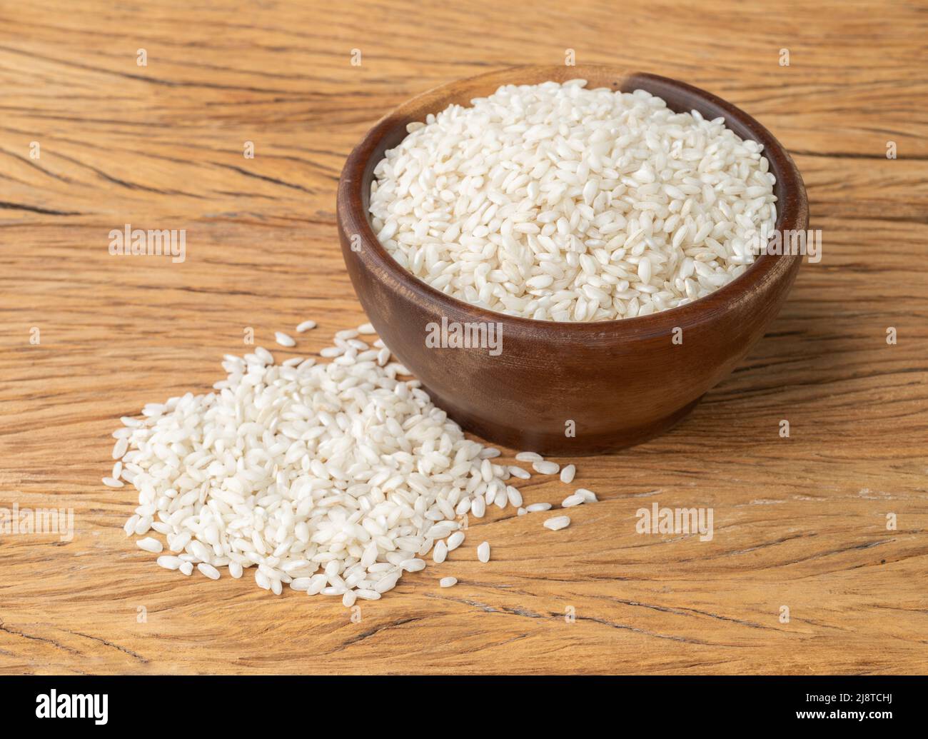 Riz carnaroli risotto cru dans un bol sur table en bois. Banque D'Images