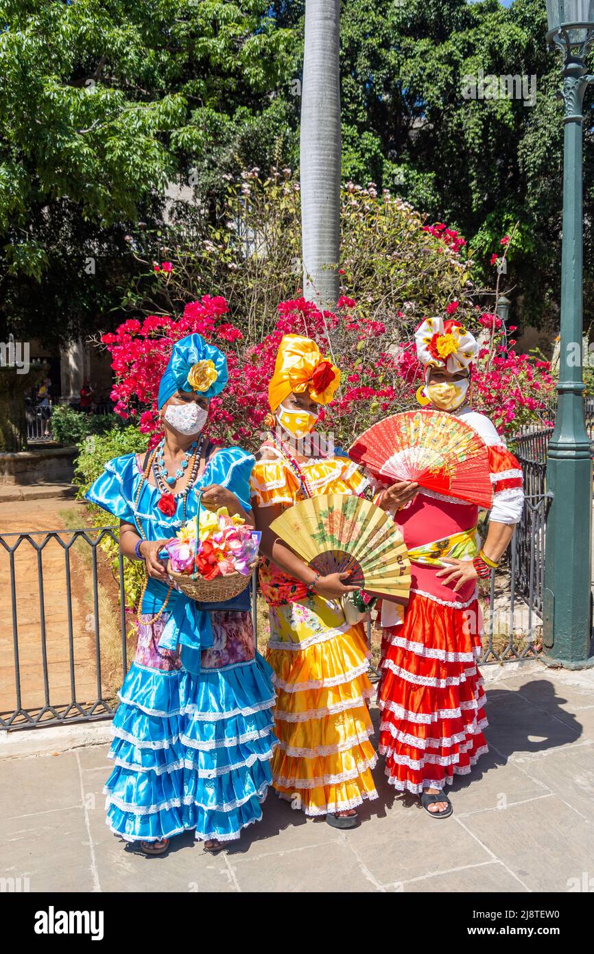 Fleurs colorées filles posant dans le jardin central, Plaza de Armas, la Vieille Havane, la Havane, la Habana, République de Cuba Banque D'Images