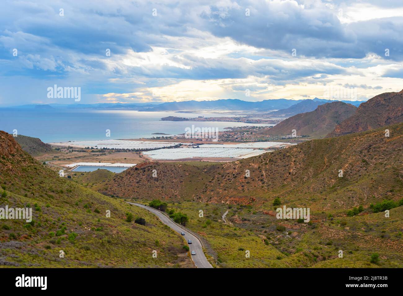 Paysage avec montagnes et village en bord de mer vue sous ciel orageux, sud de l'Espagne Banque D'Images