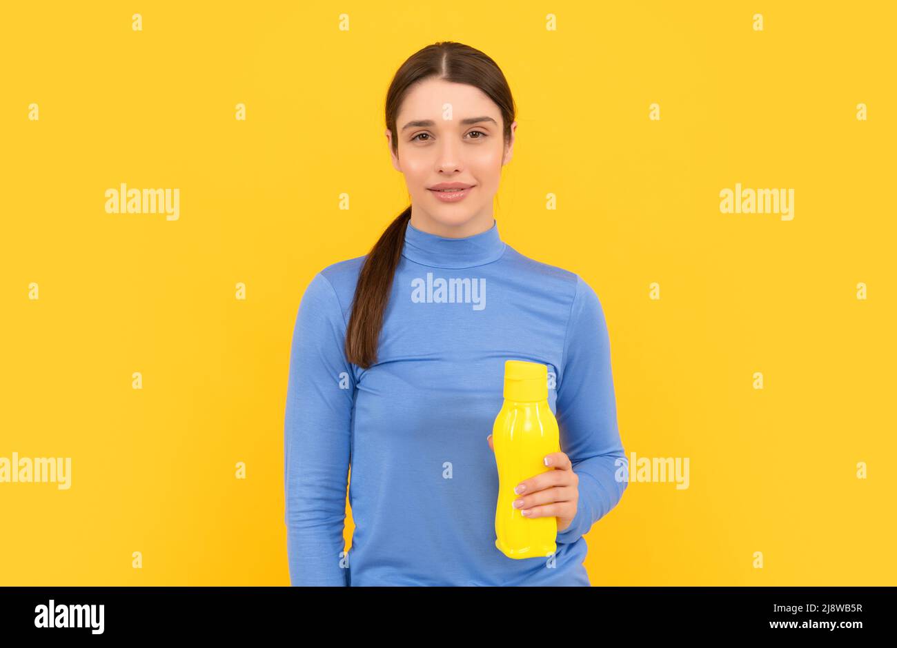 être hydratée. femme souriante tient l'eau minérale. se sentir soif. jeune fille avec bouteille de plastique de sport Banque D'Images