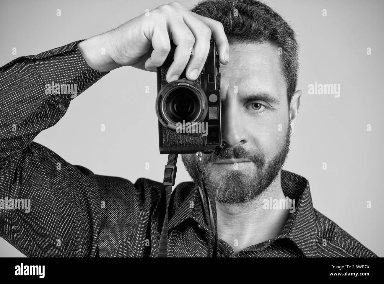 Photographe d'âge moyen Prenez une photo en regardant à l'œil de l'appareil photo portable, photo. Banque D'Images