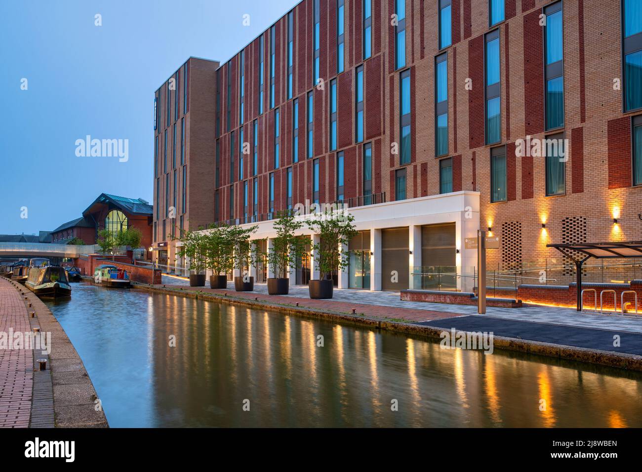 Les lumières du Premier Inn se reflètent dans le canal d'Oxford à Banbury à l'aube. Front de mer de Castle Quay. Banbury, Oxfordshire, Angleterre Banque D'Images