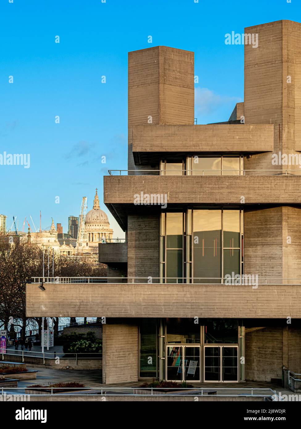 La façade brutaliste du Théâtre national de Londres, avec la cathédrale baroque anglaise St Paul au loin. Banque D'Images