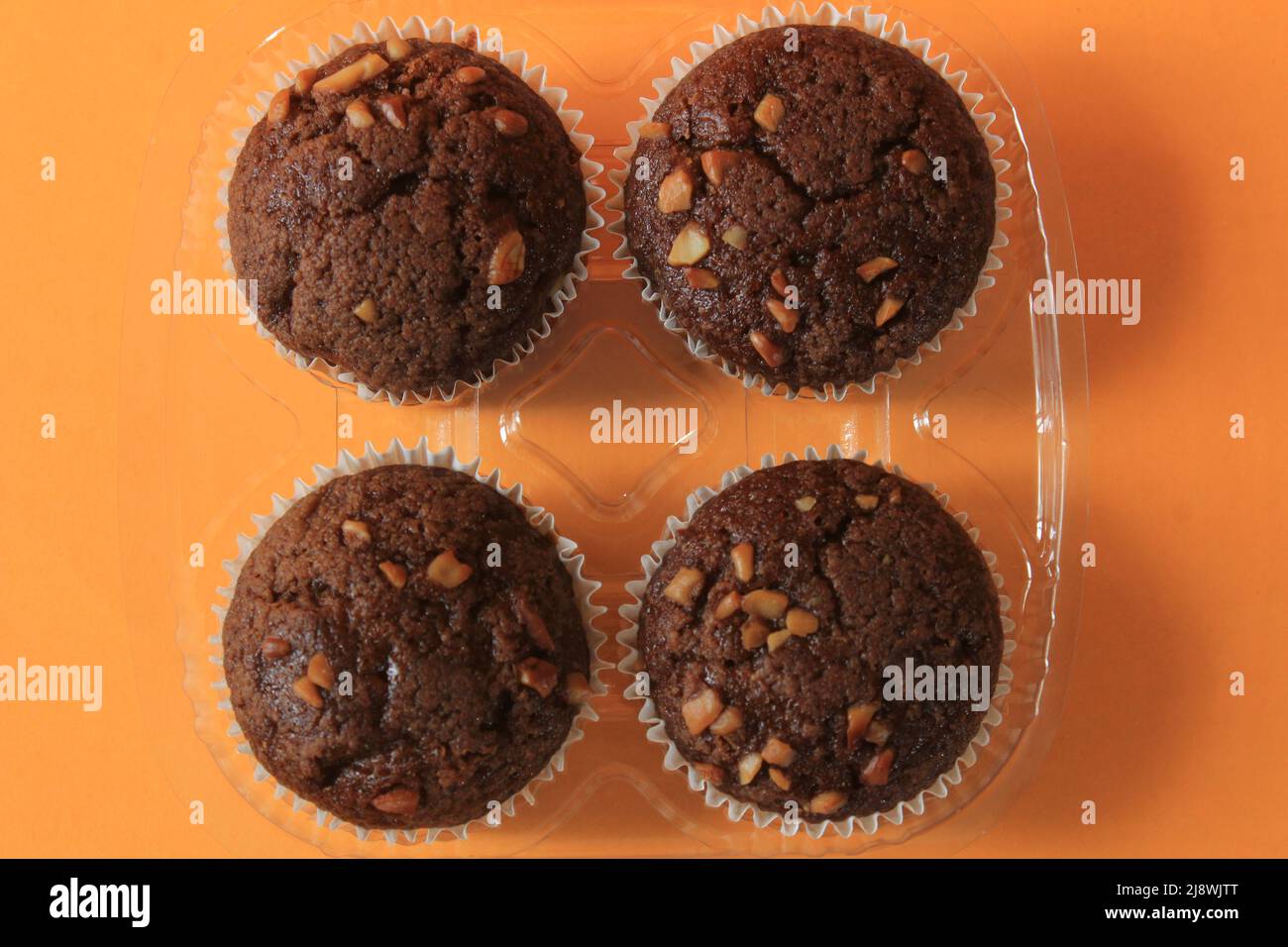 Muffin au chocolat isolé sur fond de couleur. Délicieux muffin au chocolat avec noix. Banque D'Images