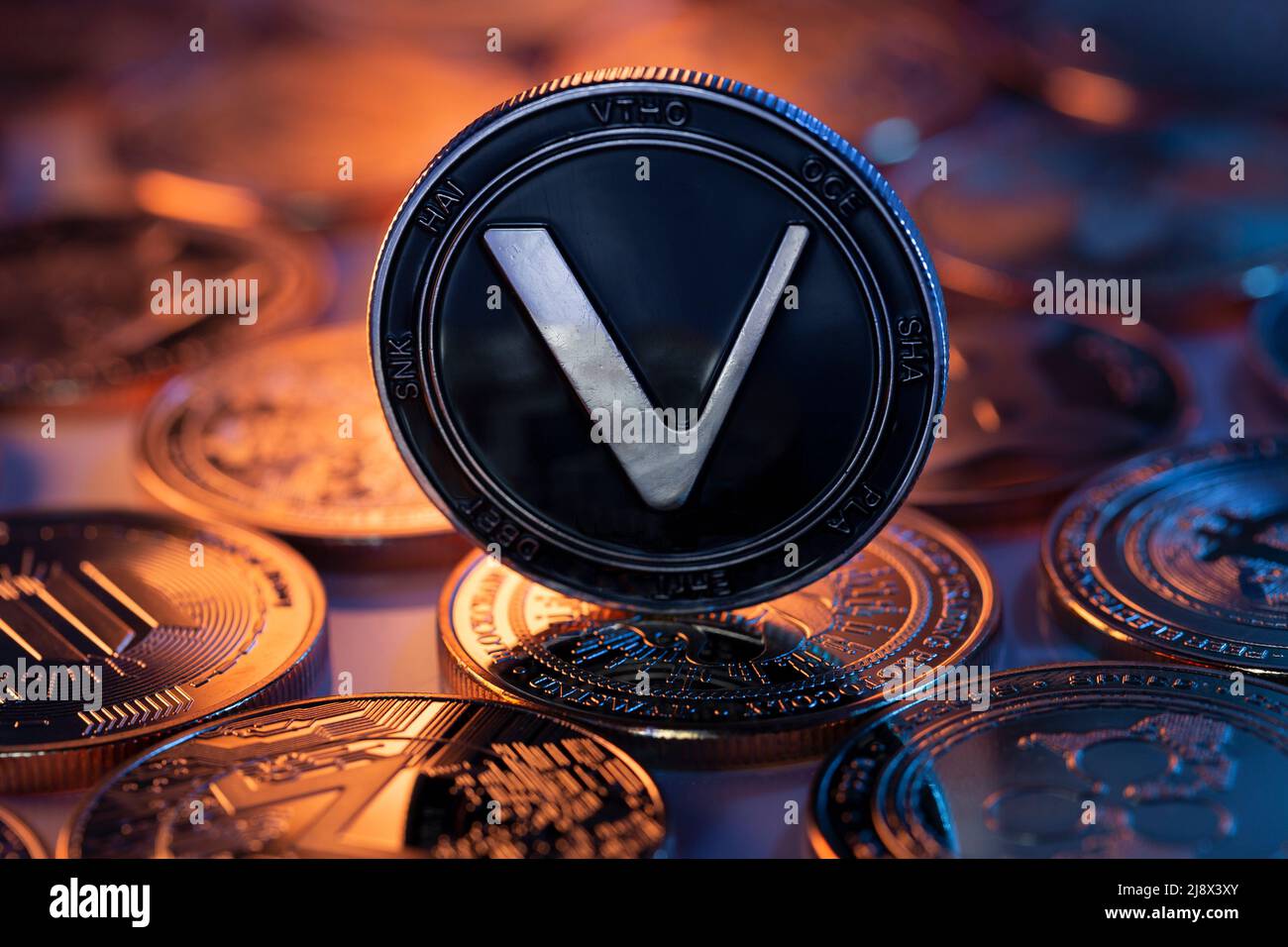 VeChain VET crypto-monnaie physique placée sur une surface réfléchissante  et éclairée par des lumières bleues et violettes Photo Stock - Alamy
