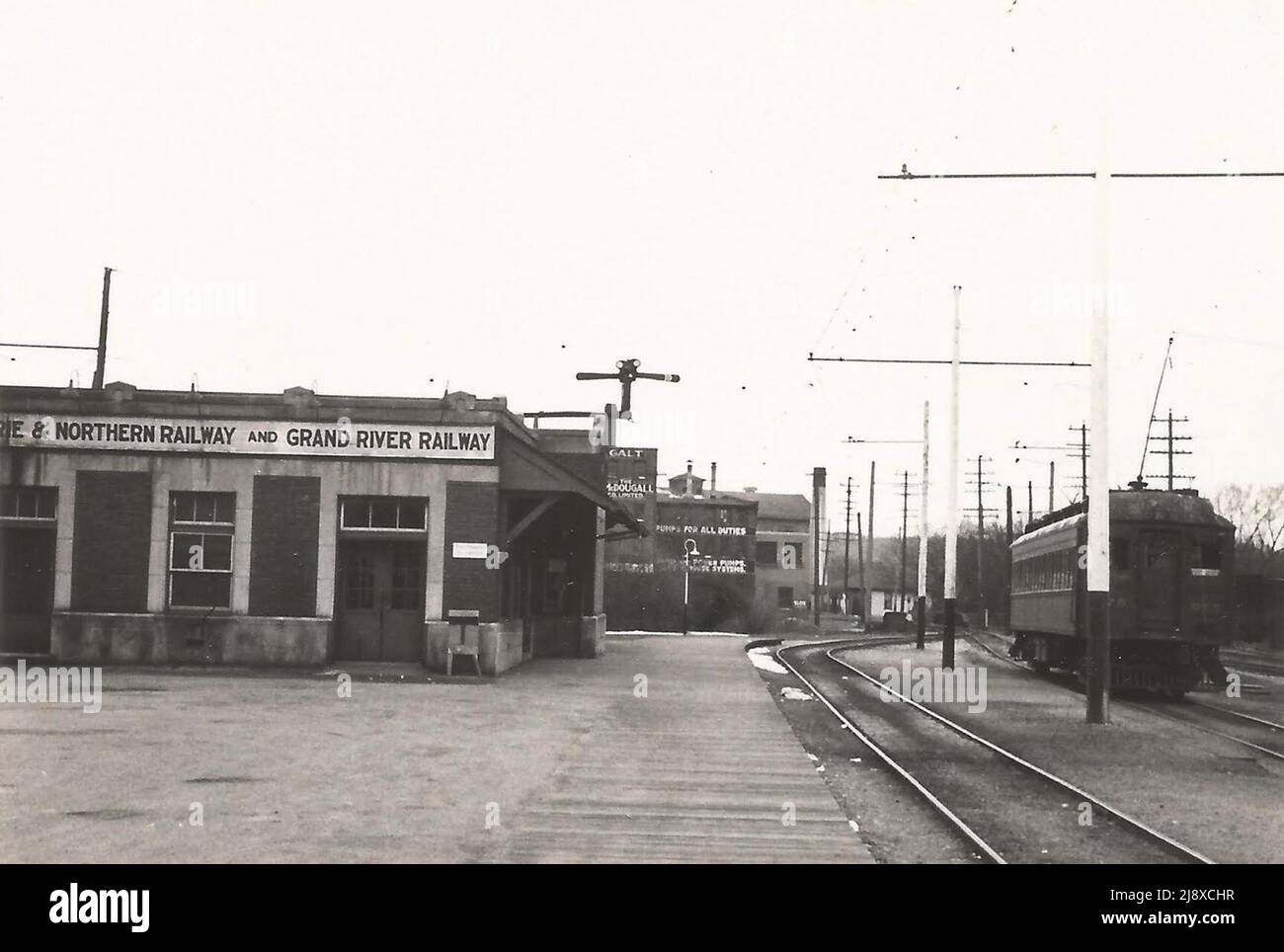 Gare et voiture à Galt (1 km de la gare du CP) cette photo prise le 20 avril 1947 montre la gare commune Grand River Railway/Lake Erie et Northern Railway à main Street à Galt, Ontario, Canada, avec une voiture interurbaine non identifiée à droite. Au centre de la photographie, une preuve des opérations industrielles de Galt à l'époque est visible en arrière-plan Banque D'Images