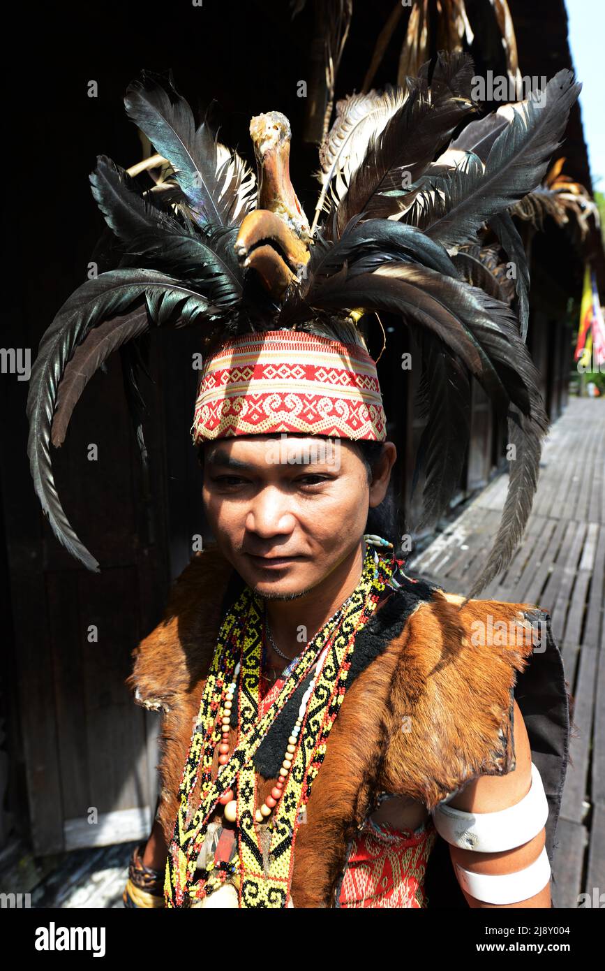 Un jeune homme de l'IBAN dans le chasseur de tête de guerrier régalia, y compris le headaddress de plumes de charme, au village culturel de Sarawak près de Kuching, Sarawak, Malaisie. Banque D'Images