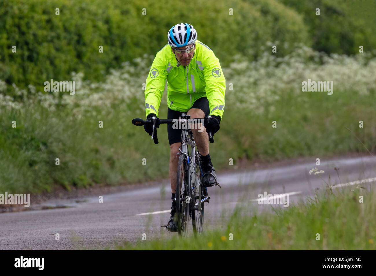 Cycliste portant des vêtements de pluie haute viz Banque D'Images