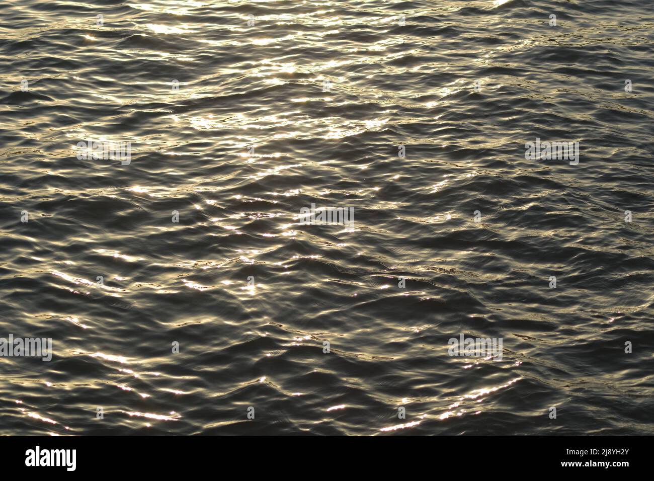Le soleil se reflète dans les vagues de la mer au coucher du soleil Banque D'Images