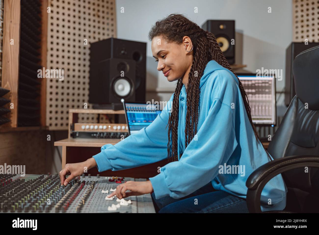 Ingénieure audio féminine élégante, productrice travaille dans un studio d'enregistrement de musique, utilise un tableau de mixage, un logiciel pour créer une chanson cool Banque D'Images