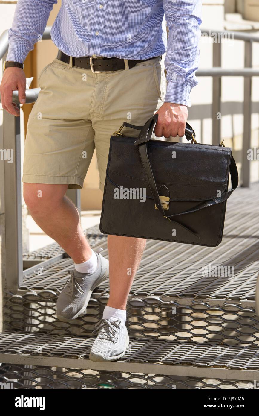 Photo partielle d'un homme avec un porte-documents en cuir marron avec un  aspect ancien et rétro. Photo à l'extérieur Photo Stock - Alamy