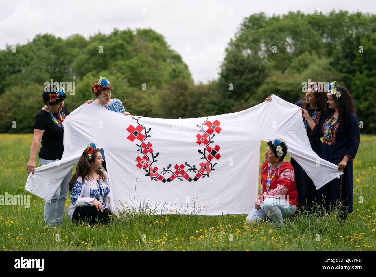 Kristina Korniiuk, 34 ans, (troisième à gauche), originaire de Kiev et qui a fui l'Ukraine après l'invasion russe, marque la célébration ukrainienne de la Journée Vyshyvanka avec une chemise traditionnelle géante, près de la maison de son hôte Rend Platings (deuxième à droite) à Cambridge. Date de la photo: Jeudi 19 mai 2022. Banque D'Images