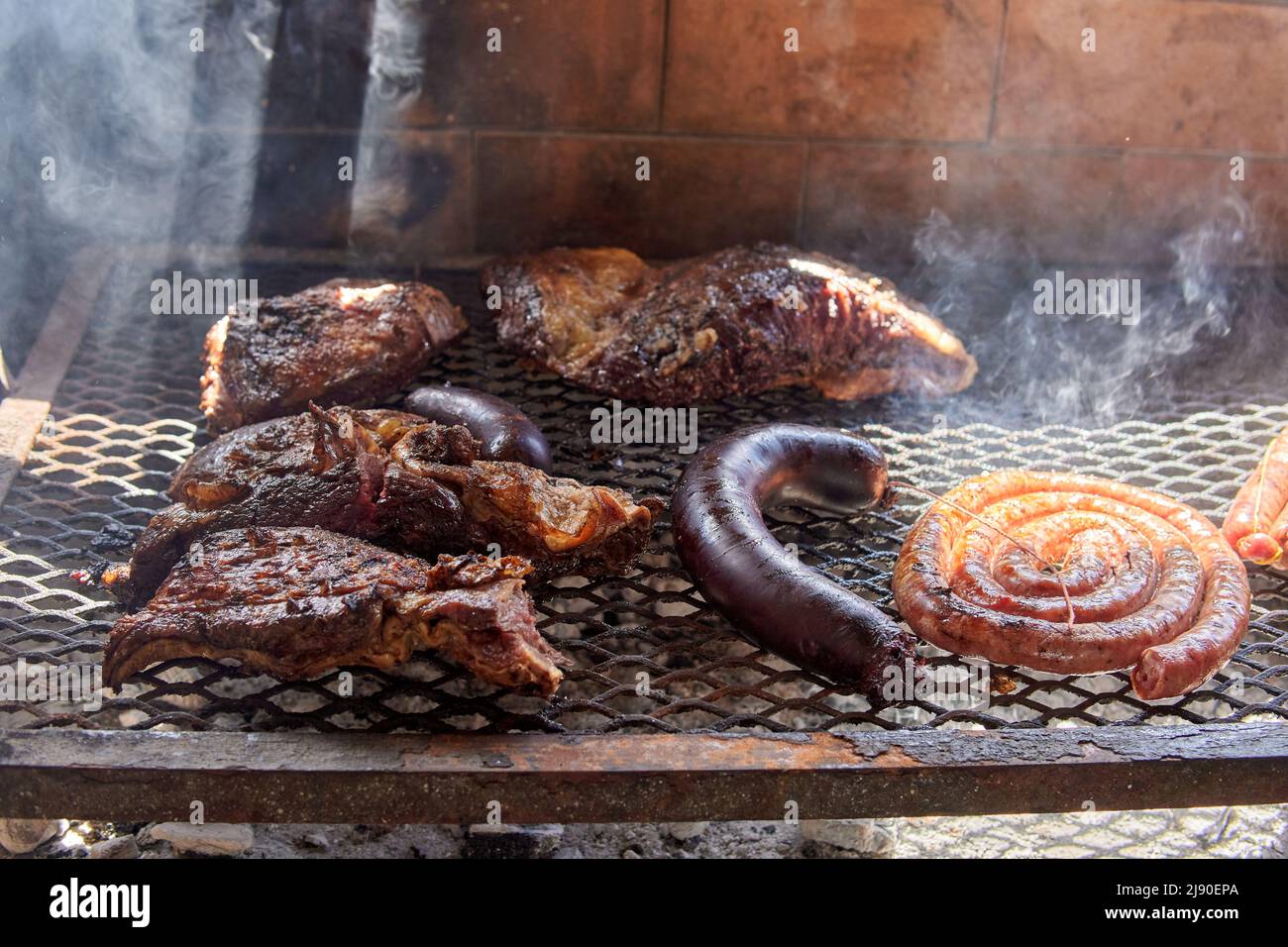 Gros plan du barbecue argentin sur le grill. Petites côtes levées, spirales de saucisse au barbecue et saucisse de sang, bœuf Banque D'Images