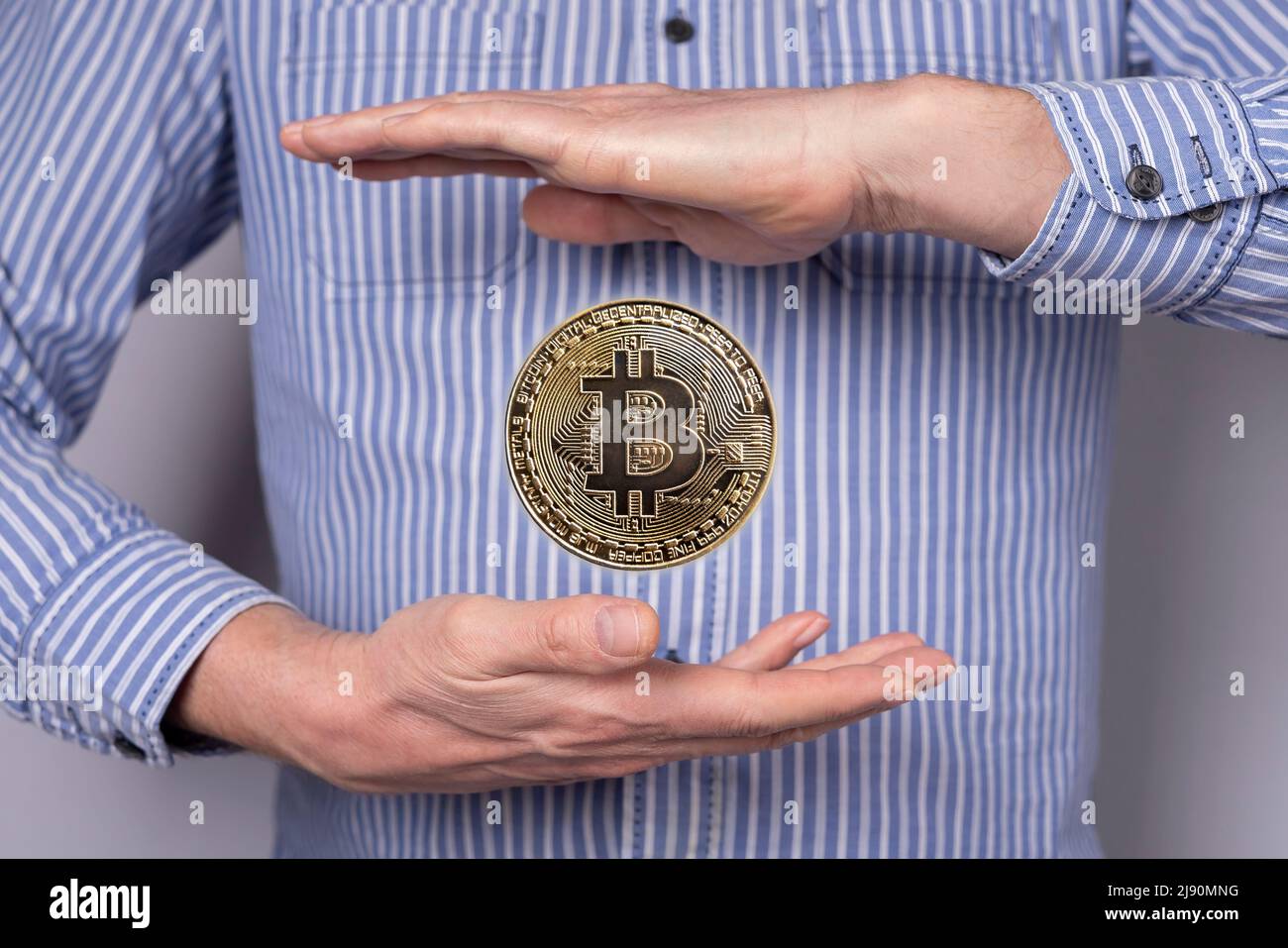 Pièce de monnaie Bitcoin volante entre les mains de l'homme. Crypto-monnaie, concept de monnaie virtuelle dans un style abstrait. Technologie blockchain, marché boursier. Photo de haute qualité Banque D'Images