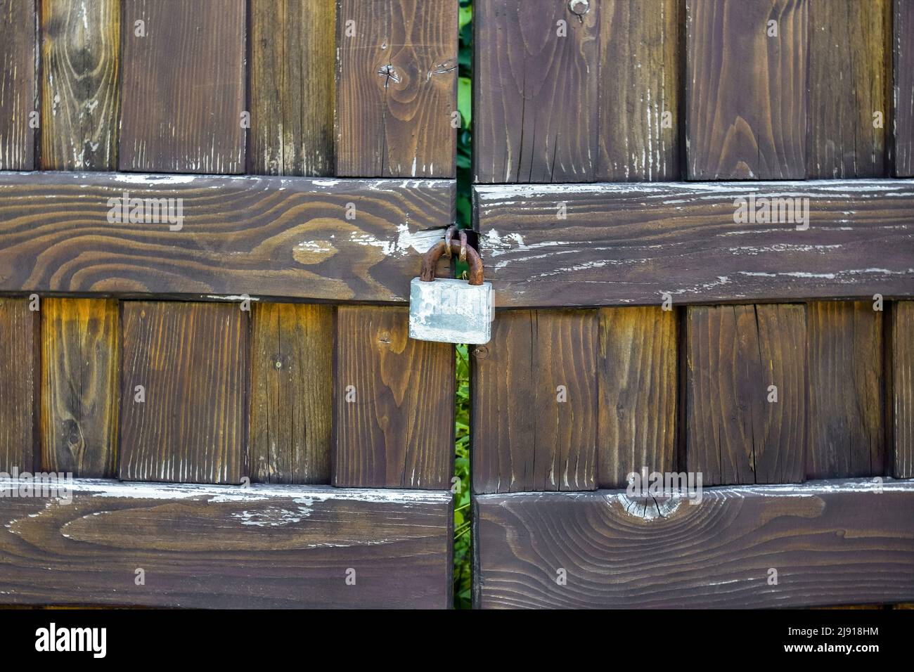 Ancienne porte en bois fermée avec cadenas rouillé. Bois qui a foncé avec l'âge. Copier l'espace. Mise au point sélective. Banque D'Images