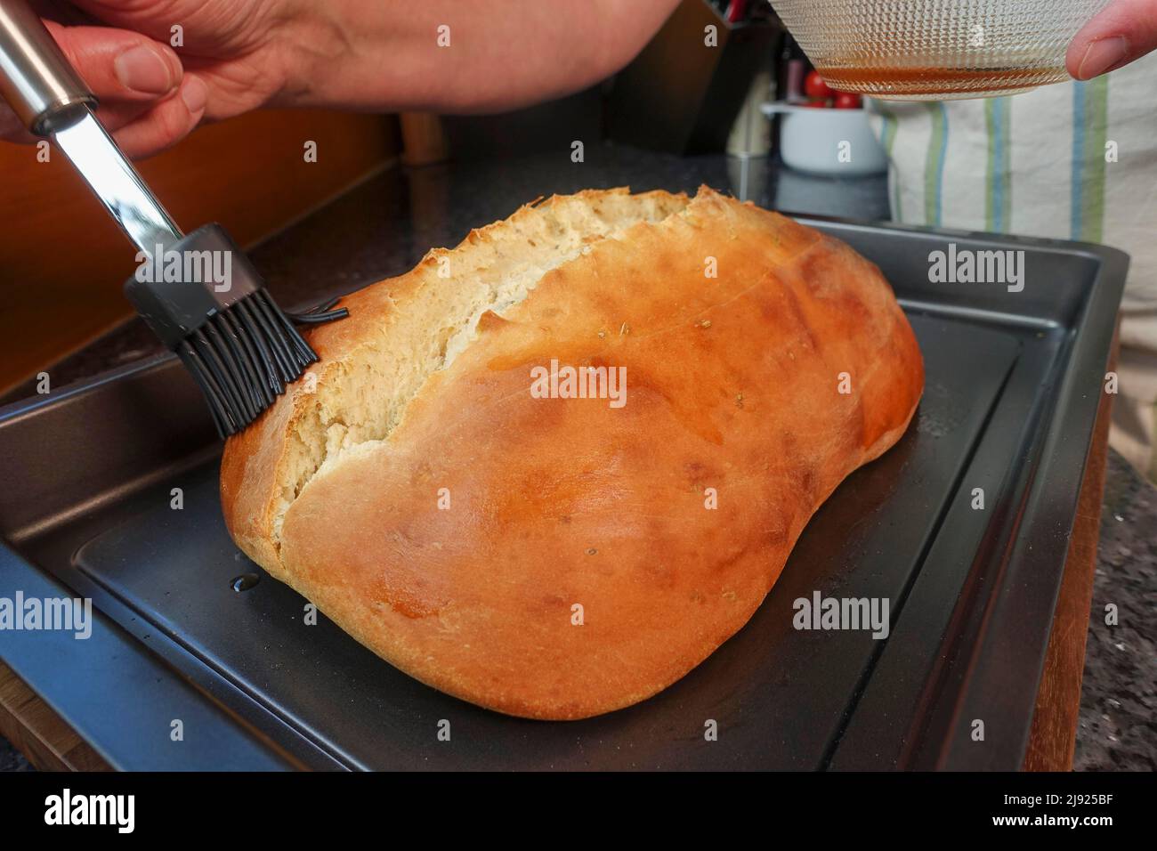 Cuisine souabe, préparation Ulmer Zuckerbrot, pâte de levure douce aux graines de fenouil, cuit, étendre le pain à l'eau de rose, pinceau Banque D'Images