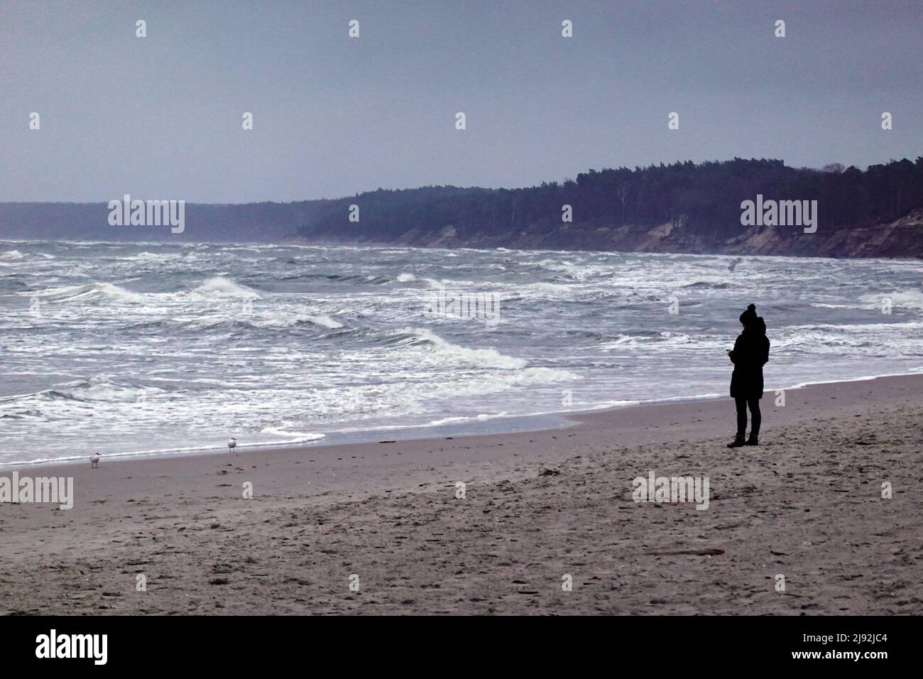 18.11.2021, Ustka, Pomerania, Pologne - femme seule sur la plage de la mer Baltique orageux. 00S211118D082CAROEX.JPG [VERSION DU MODÈLE : NON, PROPRIÉTÉ Banque D'Images