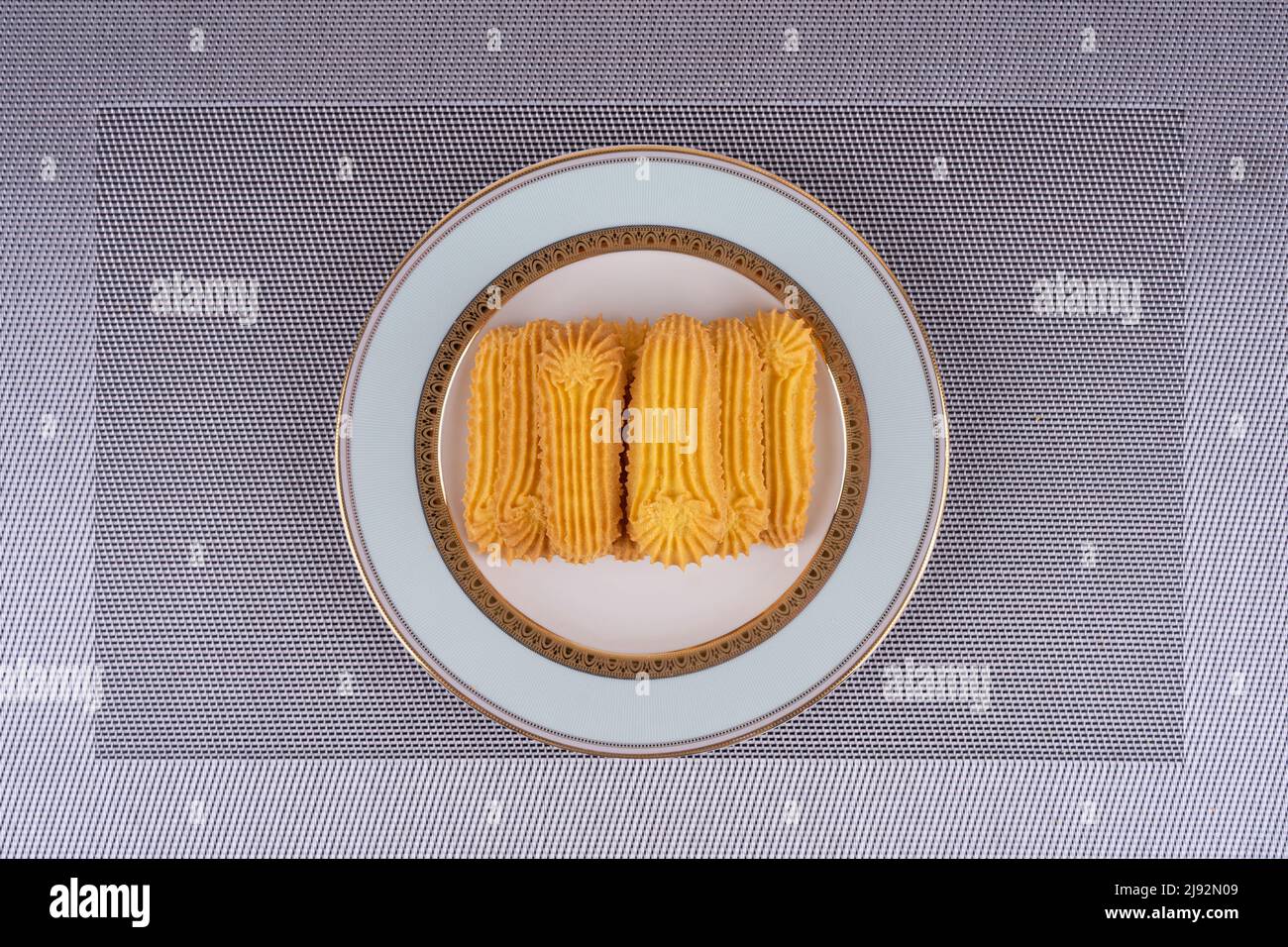 biscuits à la main sur une assiette sur fond blanc Banque D'Images