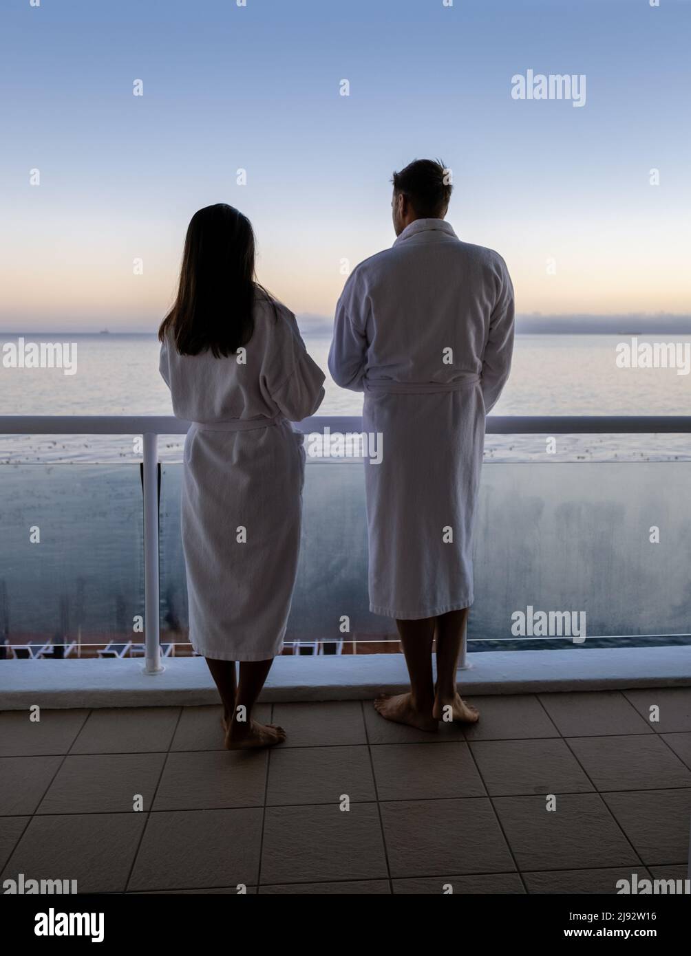 Cape Town Afrique du Sud couple homme et femmes buvant du café pendant le lever du soleil sur le balcon en vacances au Cap Afrique du Sud. Des hommes européens et des femmes asiatiques se réveillent avec un café qui donne sur l'océan Banque D'Images