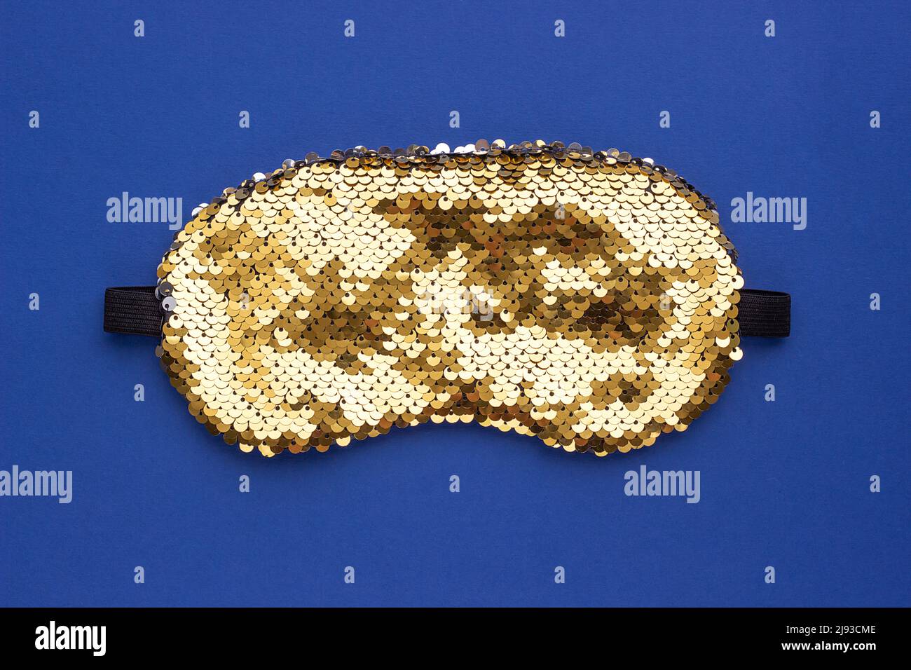 Masque de sommeil brillant pour les yeux décoré de sequins sur un fond bleu. Vue de dessus de l'espace de copie de la mise à plat. Concept de protection oculaire contre la lumière pour un bon sommeil Banque D'Images