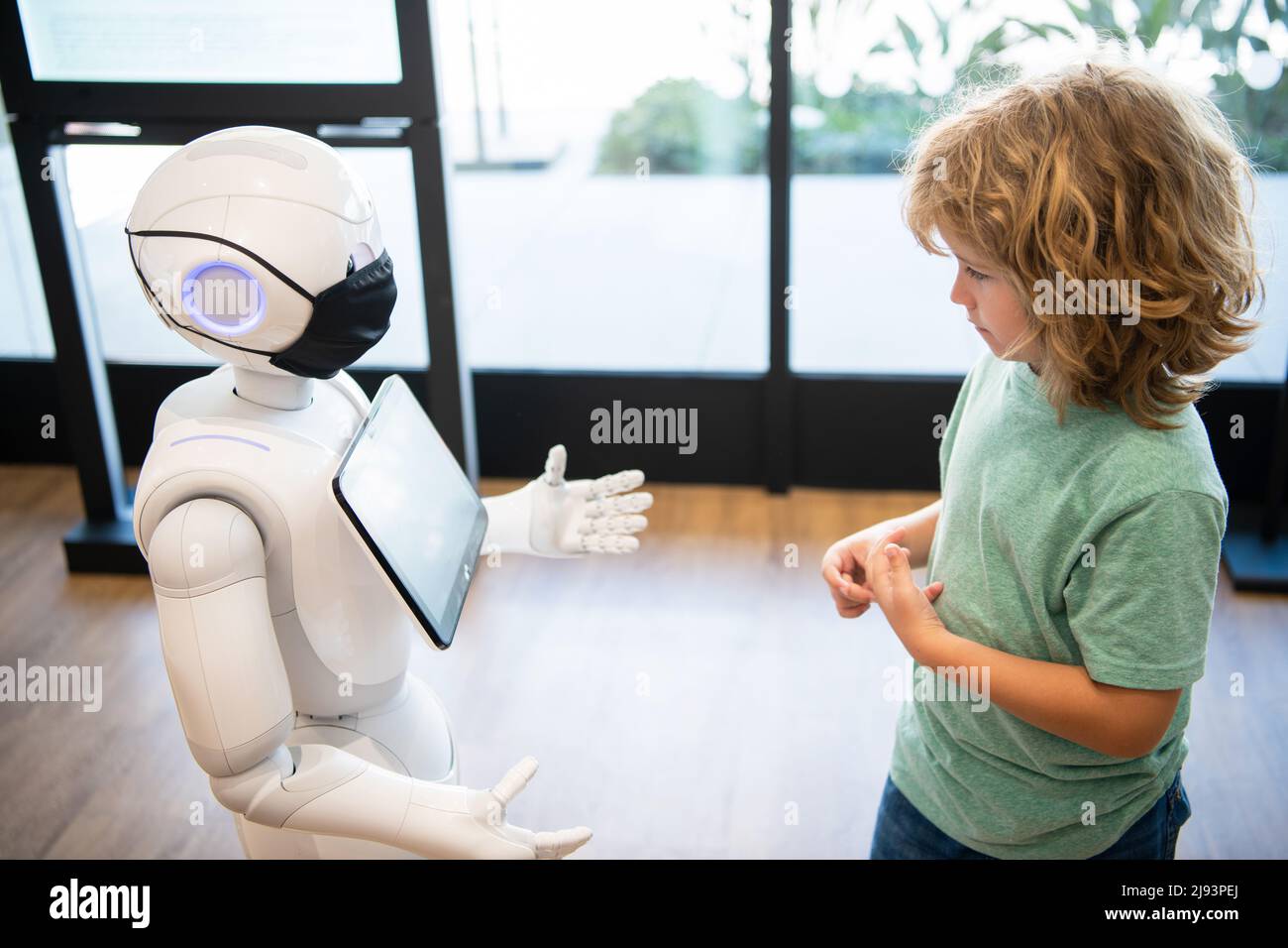 l'enfant concentré interagit avec l'intelligence artificielle de robot, la communication Banque D'Images