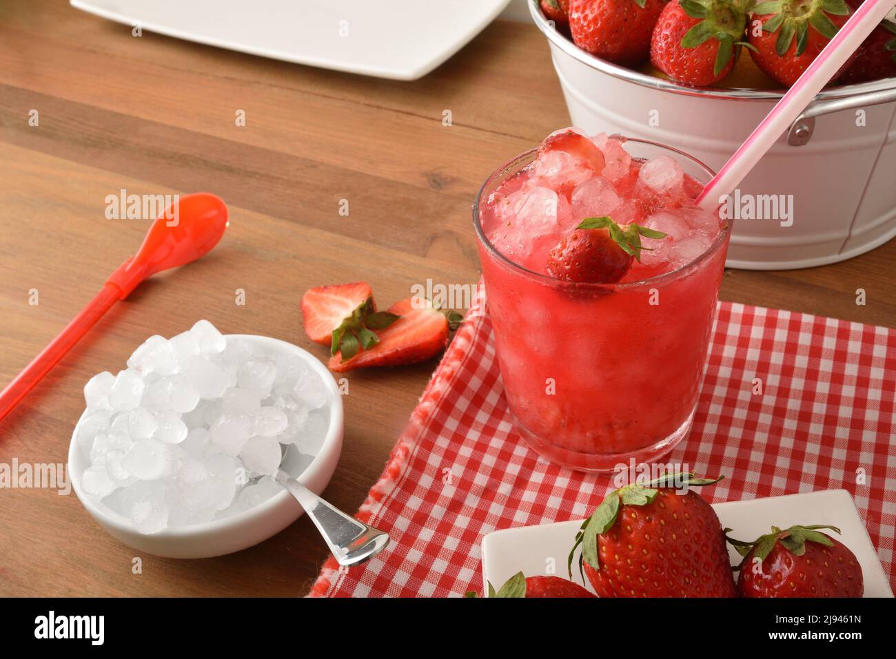 Granita de fruits avec fraises mûres et beaucoup de glace sur une table en bois avec un bol de glace et un panier rempli de fraises. Vue en hauteur. Co. Horizontale Banque D'Images