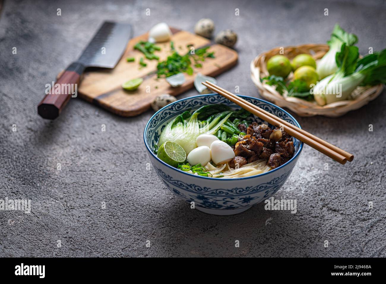 Soupe asiatique traditionnelle aux nouilles avec bok choi et poulet dans un bol en céramique. Banque D'Images