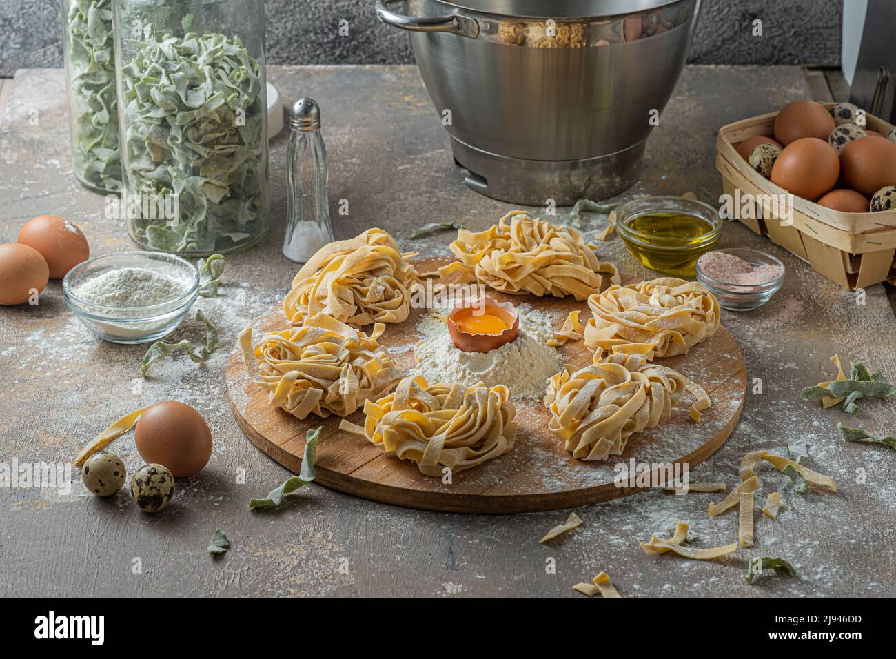 Pâtes de tagliatelle fraîchement préparées avec œufs et farine sur bois Banque D'Images