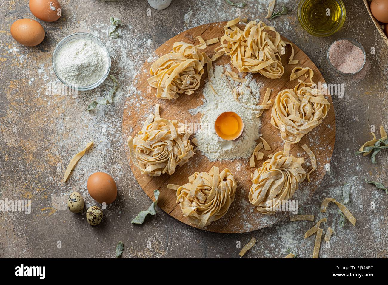 Pâtes de tagliatelle fraîchement préparées avec œufs et farine sur bois Banque D'Images