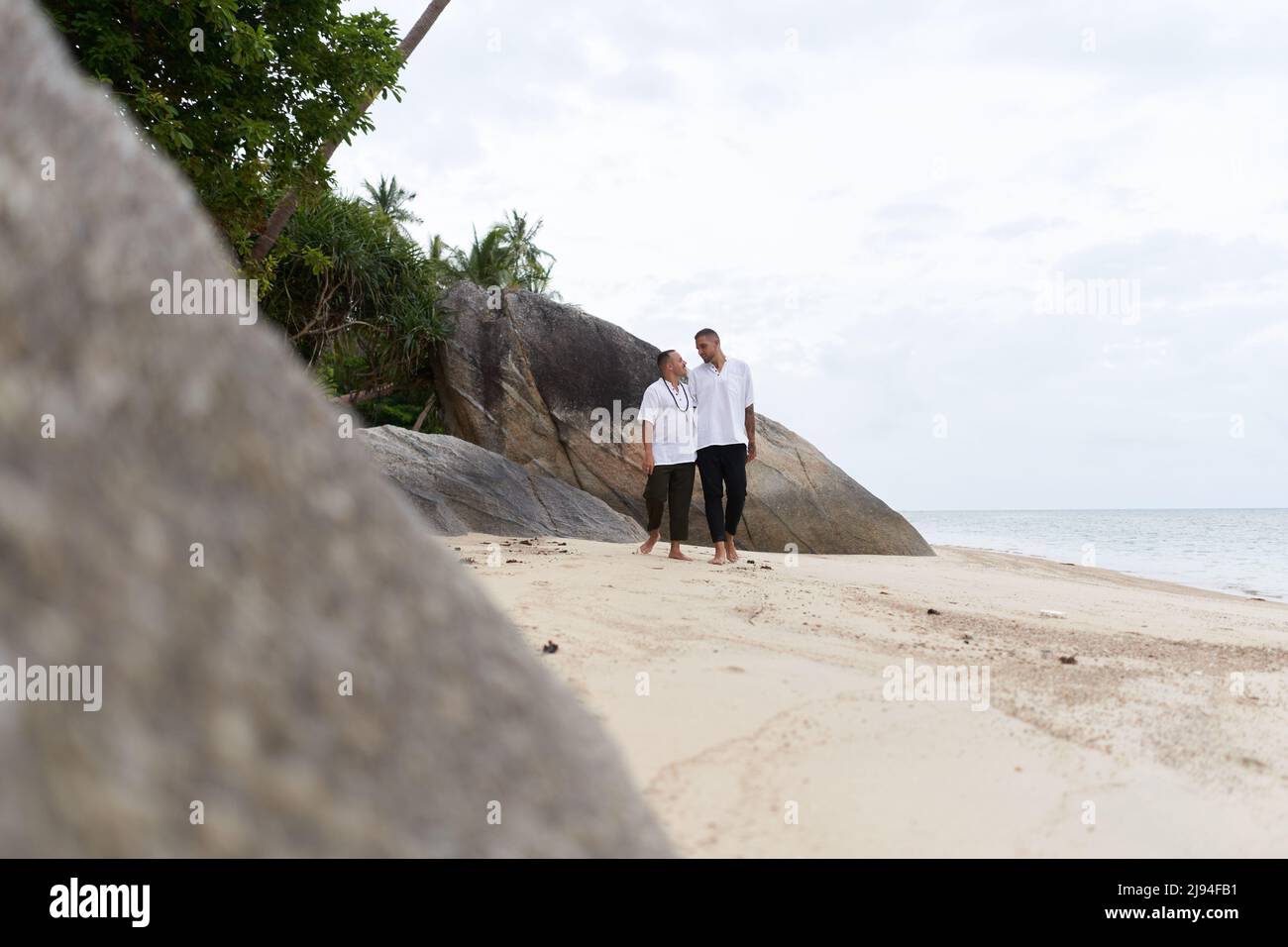 Photo avec espace de copie d'un couple gay marchant le long d'une plage Banque D'Images