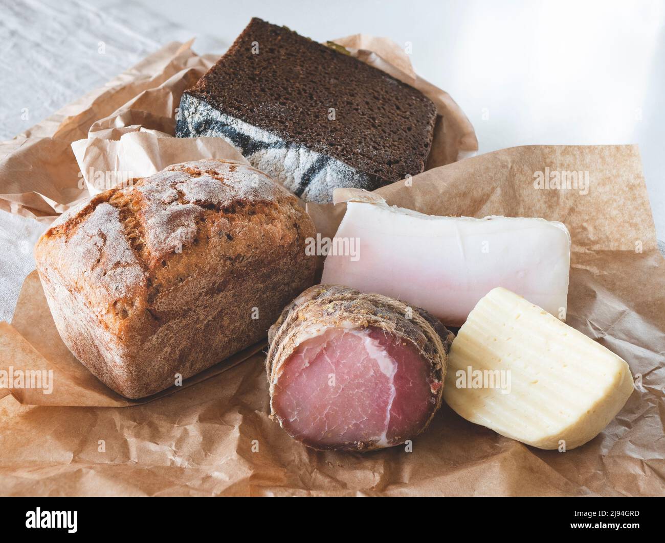 Délicieux produits régionaux sur le papier artisanal. Pain de blé et de seigle, fromage et viande, gros plan Banque D'Images