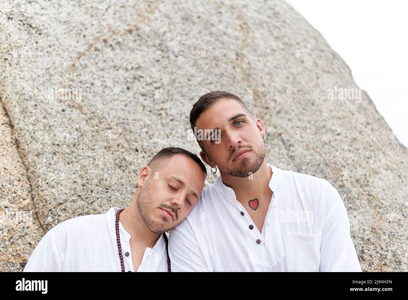 Gay homme pendu sa tête sur l'épaule de son couple sur une plage Banque D'Images