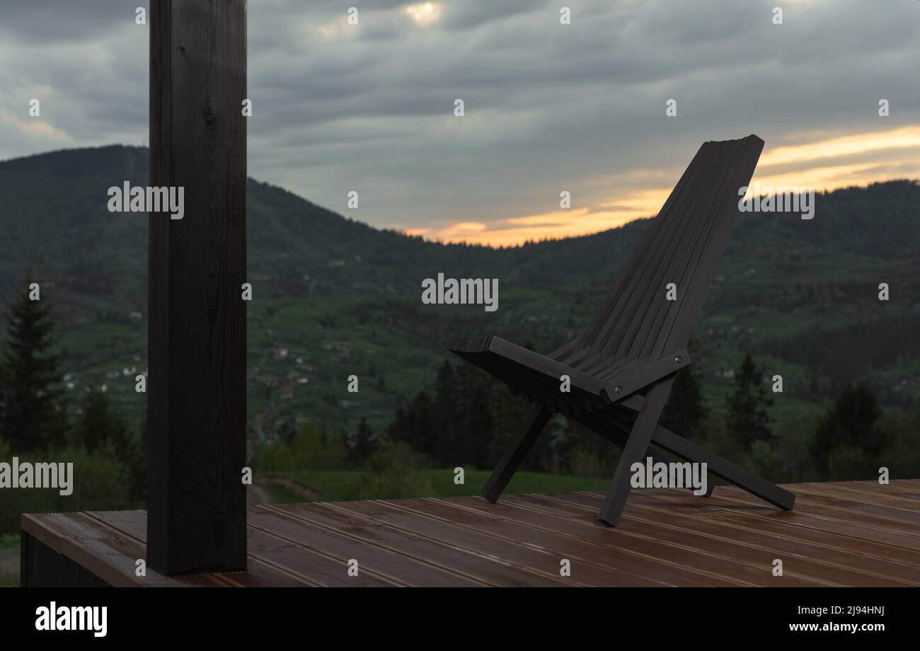 Chaise extérieure noire en bois sur la terrasse avec vue sur la montagne en arrière-plan Banque D'Images