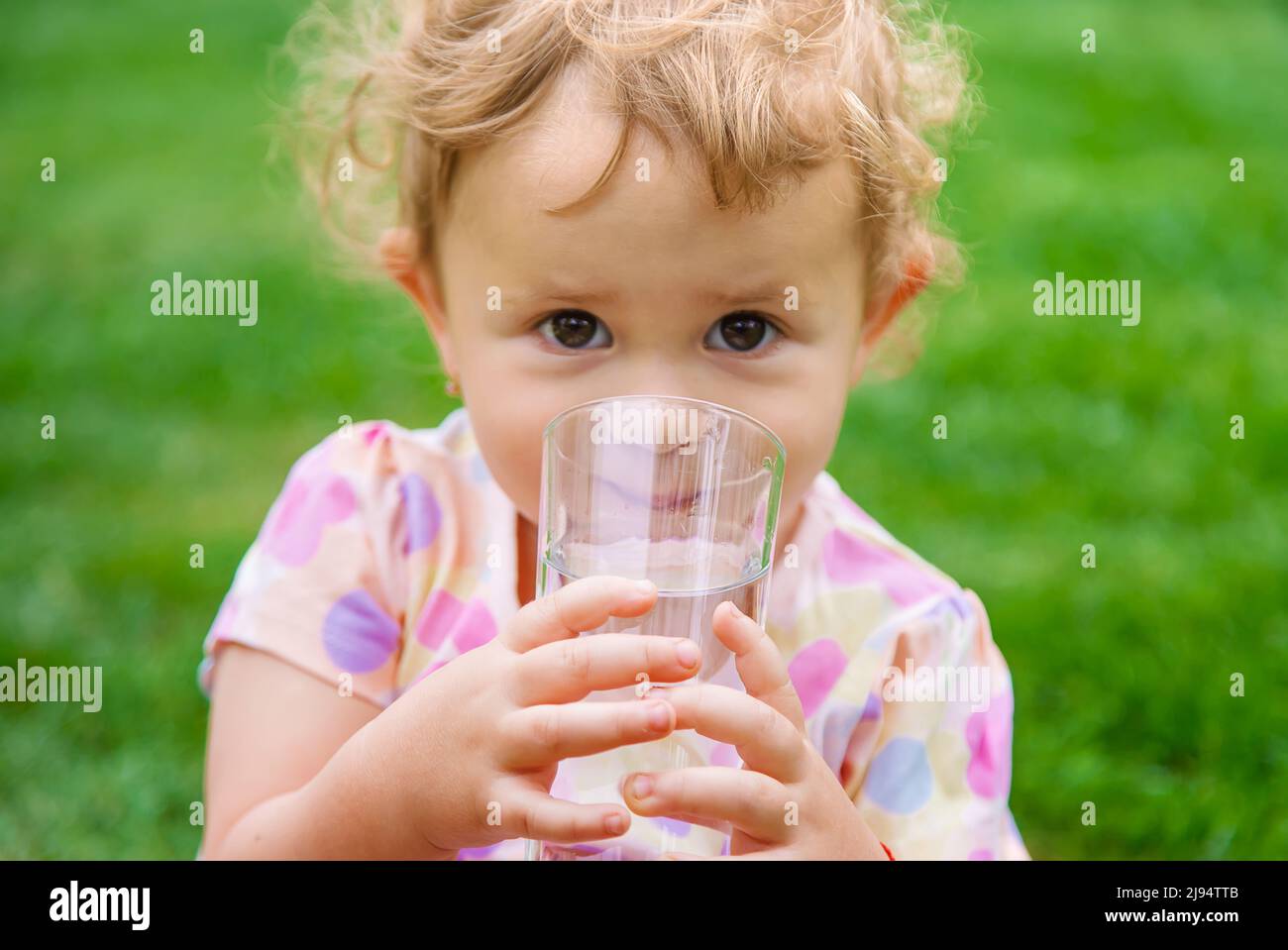 Bébé boit de l'eau dans un verre. Mise au point sélective Photo Stock -  Alamy