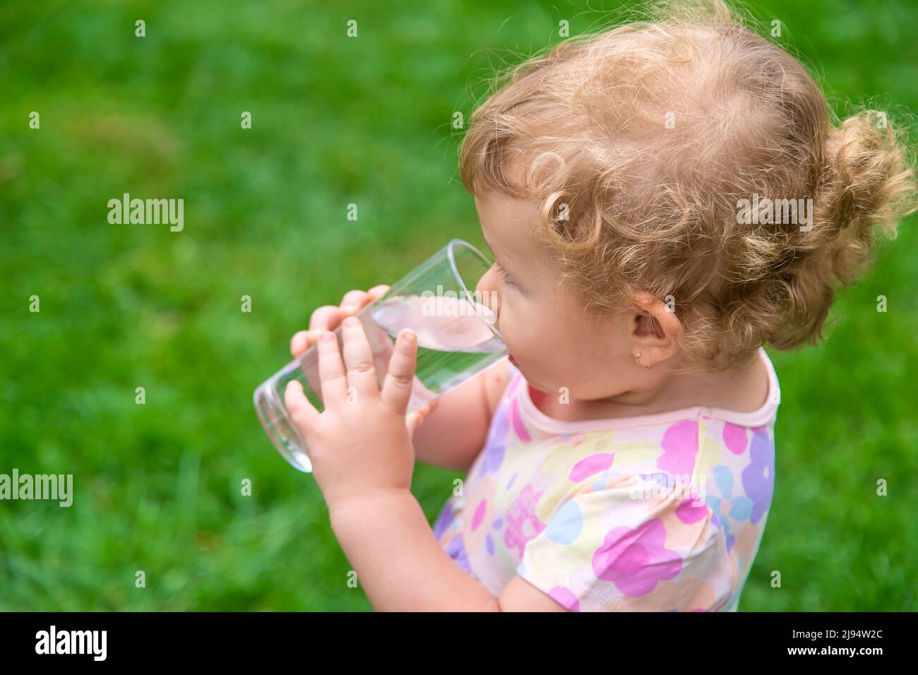 Bébé boit de l'eau dans un verre. Mise au point sélective Photo Stock -  Alamy