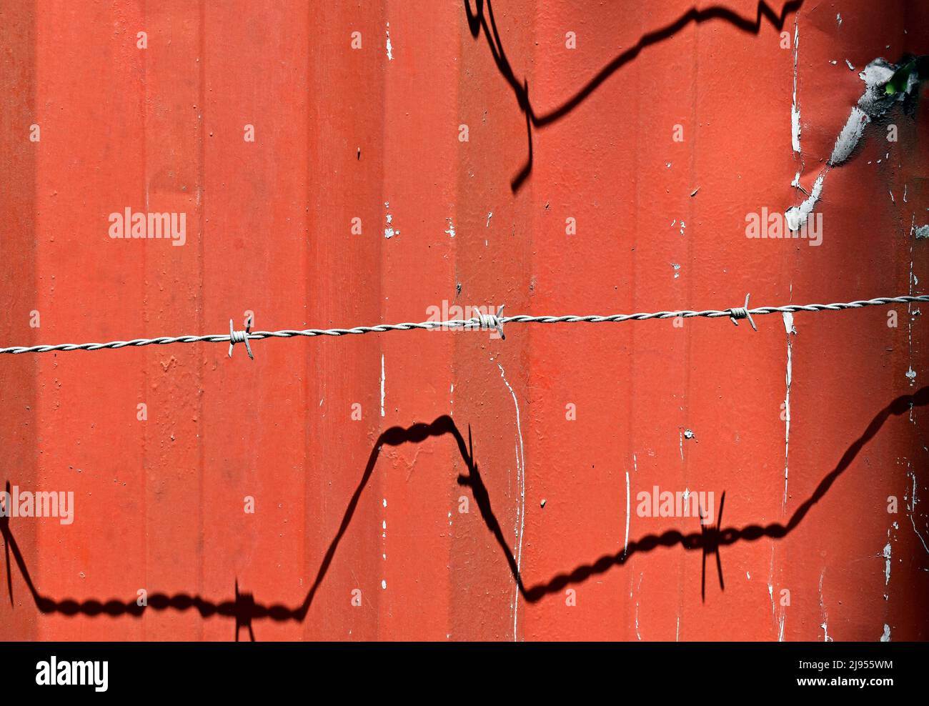 Surface métallique rouge et fil barbelé Banque D'Images
