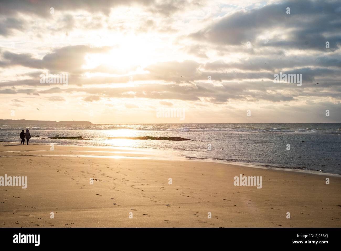 Gros plan mer plage de sable avec silhouette de couple de marche. Paysage de plage panoramique. Inspirez l'horizon marin tropical de la plage. Coucher de soleil orange et doré ciel calme tranquille détente lumière du soleil humeur d'été. Bannière vacances voyage vacances. Photo de haute qualité Banque D'Images